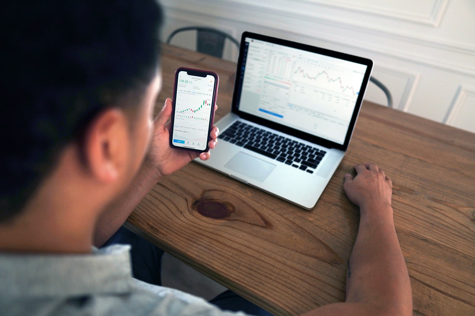 person holding iphone 6 near macbook pro life